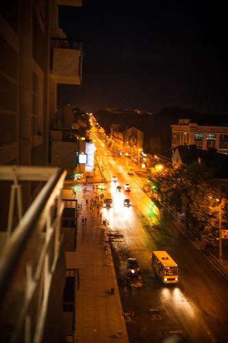 a city street at night with cars and a bus at Babylon Apartments in Rivne