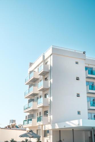an apartment building with balconies and umbrellas at Kapetanios Bay Hotel Protaras in Protaras