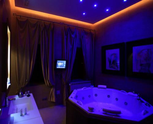 een paarse badkamer met een bad en 2 wastafels bij Hotel Boutique Palacio de la Serna in Ballesteros de Calatrava