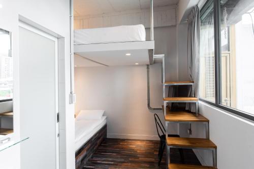 Kleines Zimmer mit einem Etagenbett und einem Schreibtisch. in der Unterkunft miniinn in Taipeh