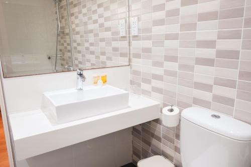 a bathroom with a sink and a toilet at Kapetanios Bay Hotel Protaras in Protaras