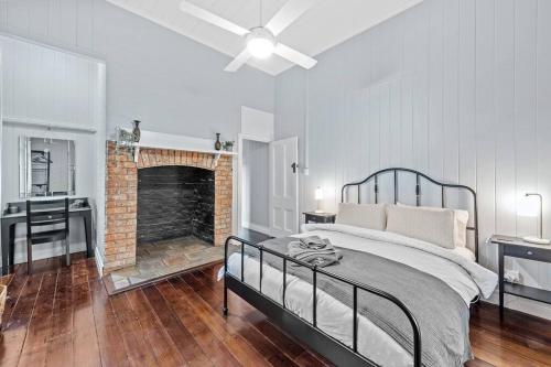 een slaapkamer met een bed en een stenen open haard bij The Fireplace! 1 Bed/1 Bath/1 Car ~ New Farm in Brisbane