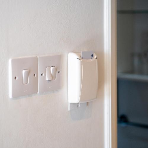 a white door with two switches on a wall at Kapetanios Bay Hotel Protaras in Protaras