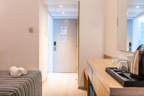 a kitchen with a counter and a sink and a door at Kapetanios Bay Hotel Protaras in Protaras