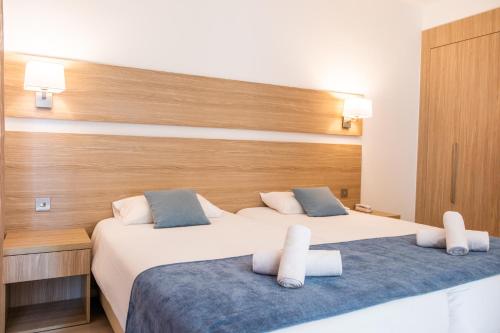 a hotel room with two beds and a headboard at Kapetanios Bay Hotel Protaras in Protaras