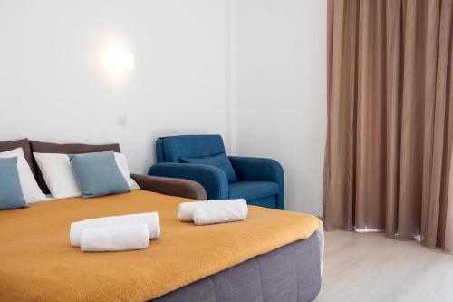 a room with two beds and a couch and a chair at Kapetanios Bay Hotel Protaras in Protaras