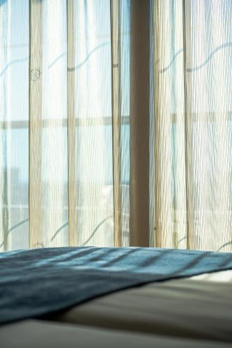 a bedroom with a bed with a window with curtains at Kapetanios Bay Hotel Protaras in Protaras