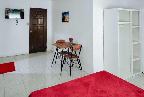 a dining room with a table and a red rug at RedDoorz at Rio Bella Lacson St Bacolod in Bacolod