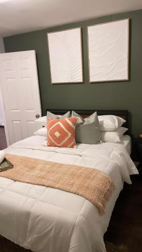 a bedroom with a large white bed with two windows at Cargo7 Cozy suites2 in North Providence