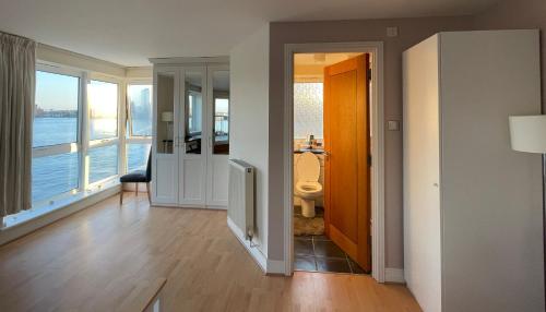 Very large ensuite room with wonderful view over the river Thames in a peaceful & calm residential building - SHARED flat with 1 host في لندن: ممر مع غرفة مطلة على الماء