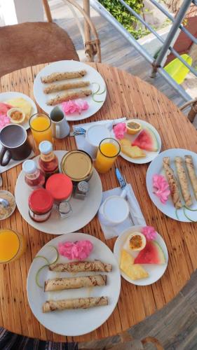 ein Holztisch mit Tellern voller Essen darauf in der Unterkunft Pamoja Beach Stays Hotel in Jambiani in Jambiani