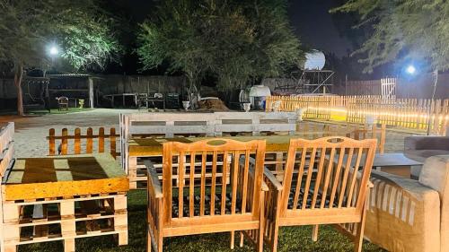 einen Tisch und zwei Stühle sowie einen Tisch und einen Tisch mit Tisch und Stühlen in der Unterkunft ONE 7 FARM (DESI PARADISE FARM ) in Dubai