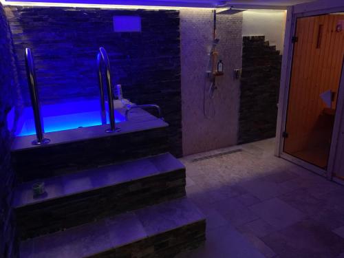 a bathroom with a walk in shower with blue lights at Apartmán Vsetín Rokytnice in Vsetín