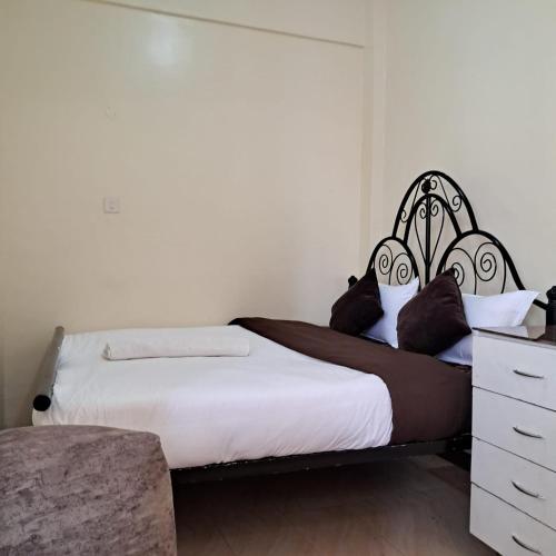 een slaapkamer met 2 bedden en een dressoir bij Ngara - Emeli in Nairobi