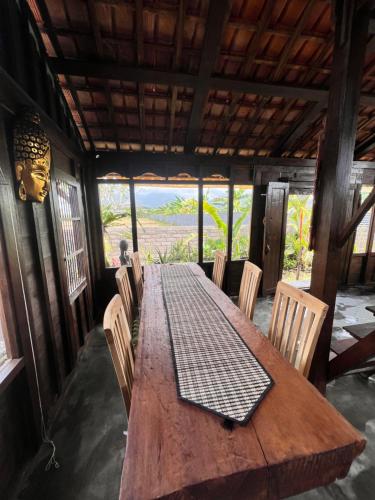 einen Holztisch und Stühle in einem Zimmer mit Aussicht in der Unterkunft Kubu Yr in Jembrana