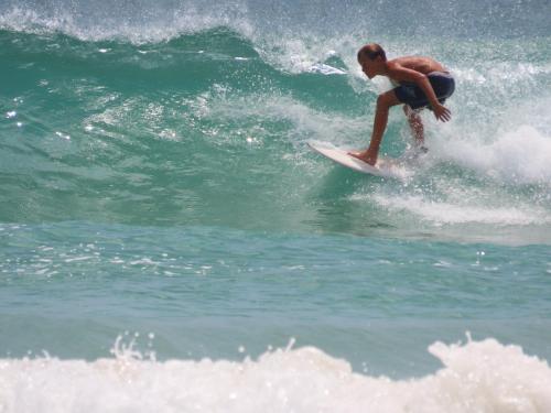 a man riding a wave on a surfboard in the ocean at Surf View Resort in Ahangama