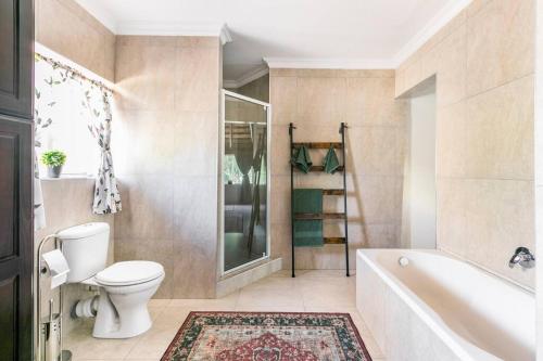 un baño con inodoro y bañera en 76 On Crestwood, en Sandton