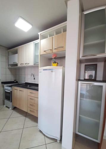 uma cozinha com um frigorífico e um fogão em Cobertura de dois dormitórios Summer Beach em Florianópolis