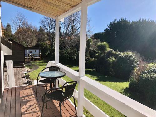 a patio with two chairs and a table on a porch at The Mountain Stable Studio in Rangataua