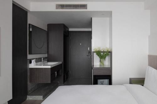 a bedroom with a white bed and a sink at Jinxi Aerial Riverview Hotel - Chongqing Jiefangbei Hongya Cave in Chongqing