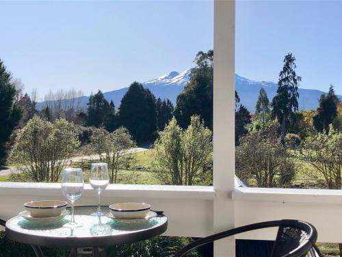 un tavolo con due bicchieri da vino e una vista sulle montagne di The Mountain Stable Studio 