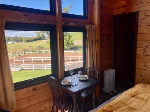 a table with two wine glasses on it in a room with windows at The Mountain Stable Studio 