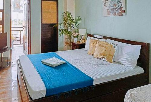 a bed with a blue blanket and pillows on it at RedDoorz @ Mary Land Transient Alaminos Pangasinan in Alaminos