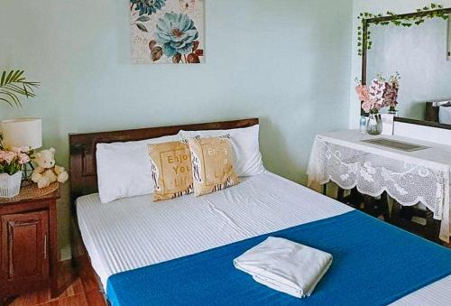 a bedroom with a bed with blue and white sheets at RedDoorz @ Mary Land Transient Alaminos Pangasinan in Alaminos