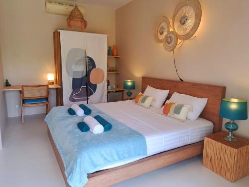 a bedroom with a large bed with pillows and a fan at Laura Guest House Samui in Lamai