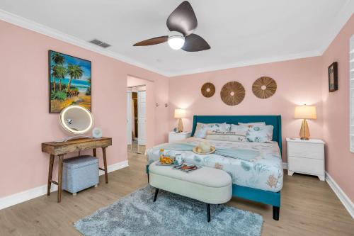 1 dormitorio con cama azul y espejo en Grand Pool Villa Minutes to the Beach! Sleeps 8!, en Boynton Beach