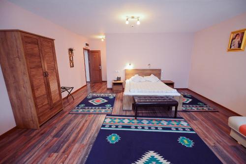 a bedroom with a bed and a room with wooden floors at Conacul Domnesc in Suceava