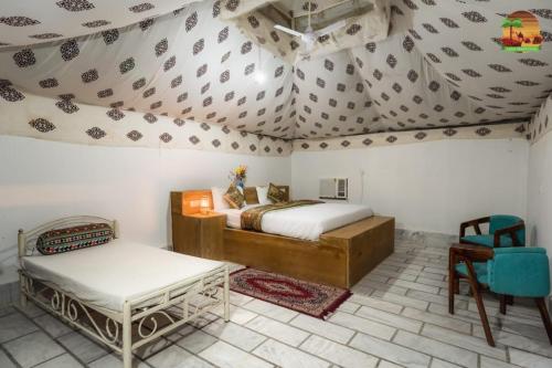 a bedroom with a bed and a table in a room at SAM DESERT RESORT in Sām