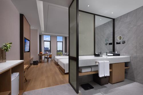 a bathroom with a sink and a large mirror at Metropark Hotel Wuhan in Wuhan