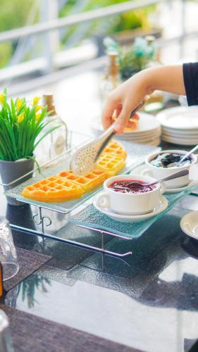 una persona sosteniendo una espátula sobre un plato de comida en Kapal Garden Hotel at Rekreasi Sengkaling, en Malang