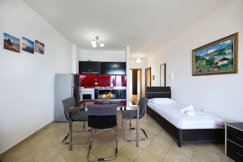 Schlafzimmer mit einem Bett, einem Tisch und Stühlen in der Unterkunft Rezidenca Panorama Apartments in Vlorë