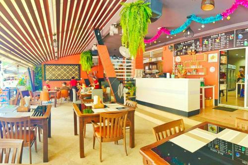 a restaurant with tables and chairs in a restaurant at Dome Resort SHA Plus in Kata Beach