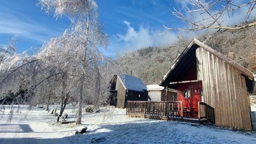 a cabin with a red door in the snow at Chalets de la Wormsa in Metzeral