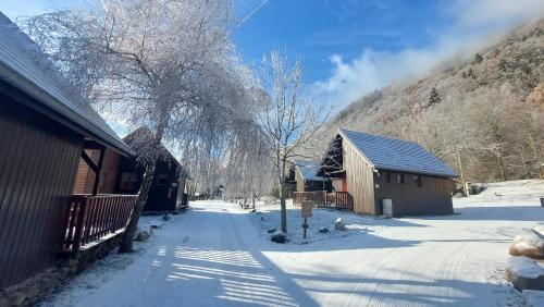 a snow covered road next to a building and a mountain at Chalets de la Wormsa in Metzeral