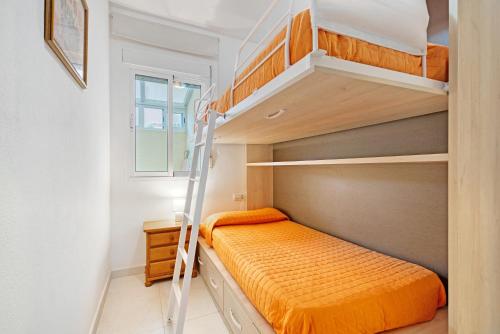 een kleine slaapkamer met een stapelbed en een ladder bij Brisas C2 in Pedreguer