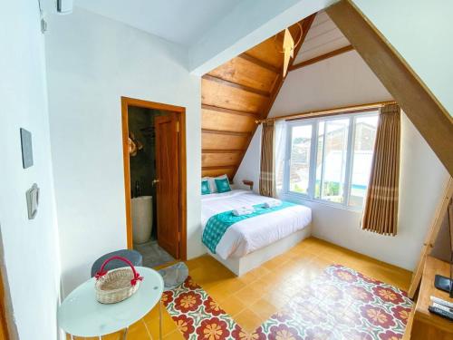 a bedroom with a bed and a table in a room at Ubu Villa Tropicola - Near Yogyakarta City Center in Seturan