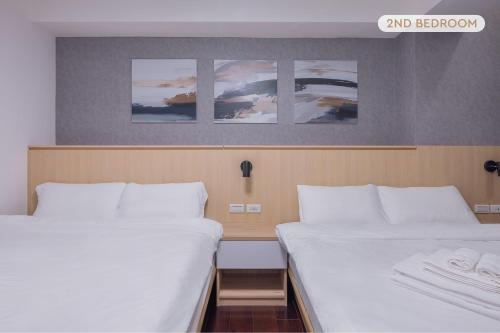 two beds in a room with three pictures on the wall at New Building Home 3B2b Daan Park MRT-2min 全新大樓家 3房2衛 2分到大安森林公園站 in Taipei