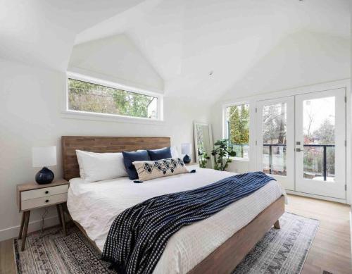 a white bedroom with a large bed and windows at New Private West Coast Guesthouse on the creek in North Vancouver
