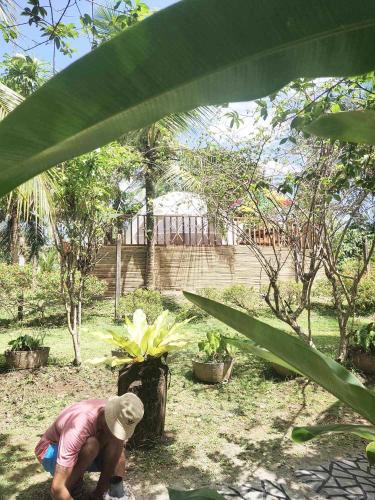 a person bending over in a garden with a plant at Eco Glamping Treehouses Closest Resort To All Tourist Attractions in Balilihan