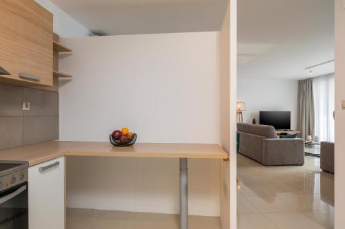 a kitchen with a table with a bowl of fruit on it at Trianon Luxury Apartments & Suites in Chania Town