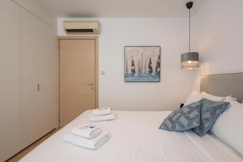 a bedroom with a white bed with towels on it at Trianon Luxury Apartments & Suites in Chania Town