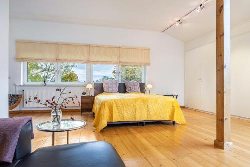 a white bedroom with a bed and a table at Landhaus Bleckede - App 2 Lüneburg in Bleckede
