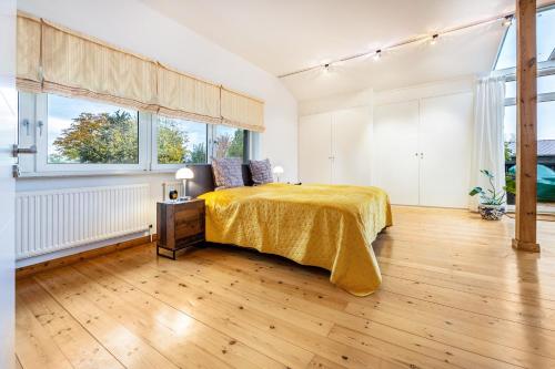 a bedroom with a bed with a yellow bedspread at Landhaus Bleckede - App Lüneburg in Bleckede