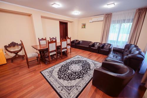 a living room with leather furniture and a dining room at Conacul Domnesc in Suceava
