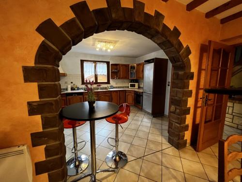 une cuisine avec une table et des chaises dans une pièce dans l'établissement Chalet de la Goutte, à La Bresse