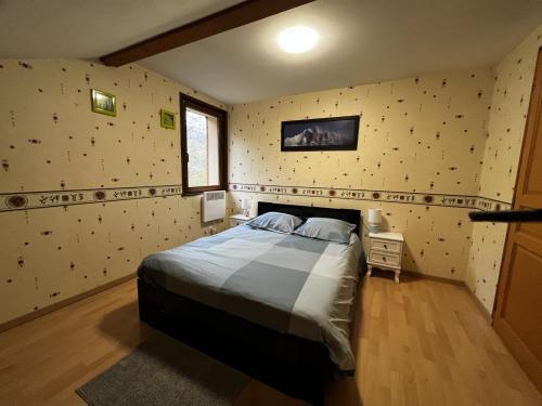 une chambre avec un grand lit dans une pièce dans l'établissement Chalet de la Goutte, à La Bresse